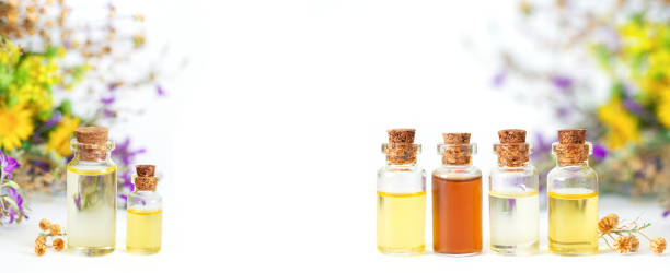 Bottles of natural cosmetic essential oils isolated on white background Glass bottles of natural cosmetic essential oils, with herbs and flowers isolated on white background. Space for text healthcare fitness and herbal medicine banner set stock pictures, royalty-free photos & images