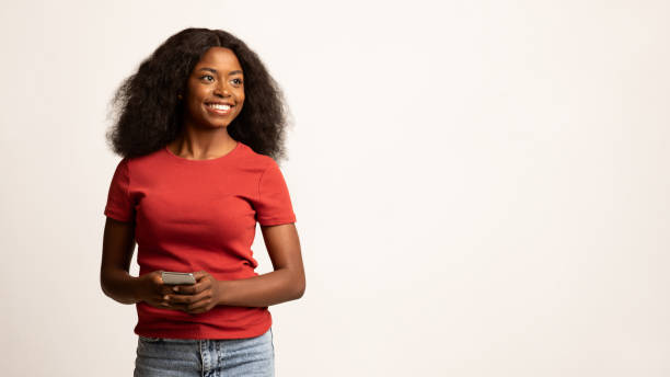 retrato de una hermosa joven mujer negra con un teléfono inteligente en las manos - black sign holding vertical fotografías e imágenes de stock