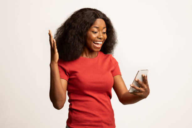 istock Online Offer. Overjoyed Black Female Looking At Cellphone Screen With Excitement 1372360879