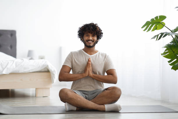 istock Happy athletic indian man meditating at home 1372360911