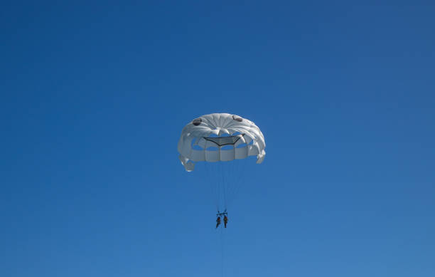 Parachuting, white parachute in sky.