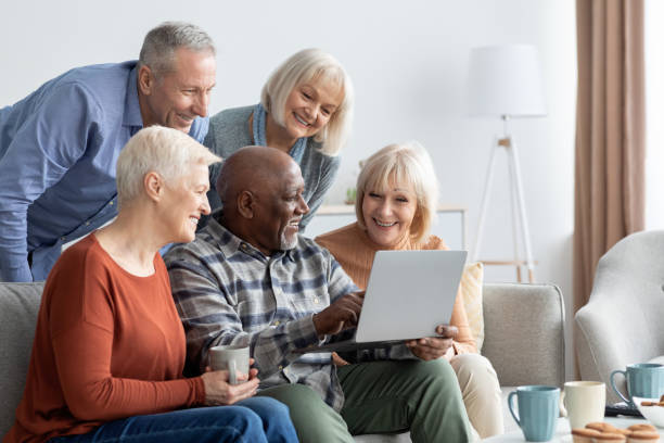istock Positive elderly people spending time together at home, using gadgets 1372362539