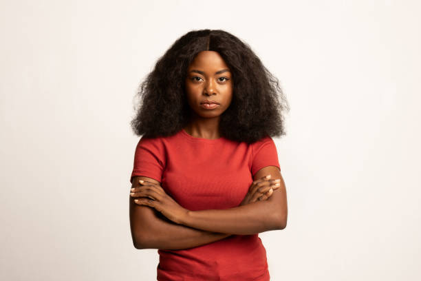 腕を組んで立っている深刻な若いアフリカ系アメリカ人女性の肖像画 - disgust women african ethnicity human face ストックフォトと画像