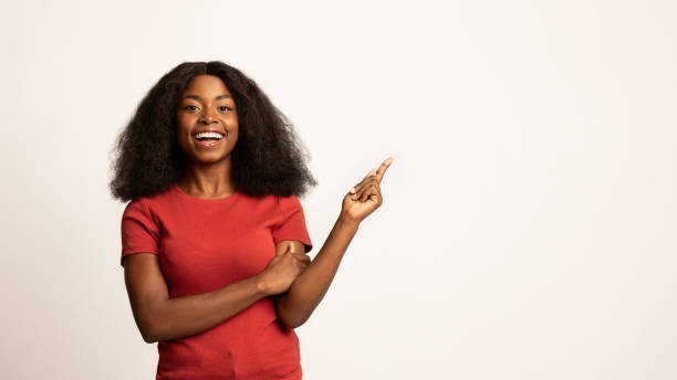 Nice Offer. Beautiful Smiling African American Lady Pointing Aside At Copy Space