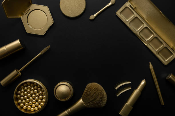 istock golden makeup cosmetics on black background. copy space 1372363131