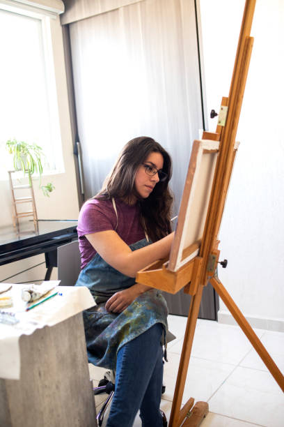 istock Young woman working on a painting 1372365691