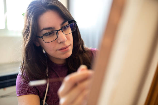 istock Young woman working on a painting 1372365710
