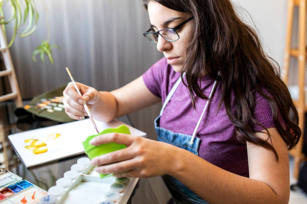 istock Young woman working on a painting 1372365768