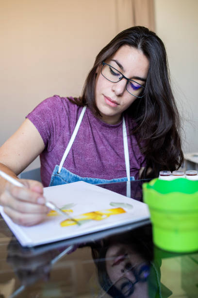 istock Young woman working on a painting 1372365870