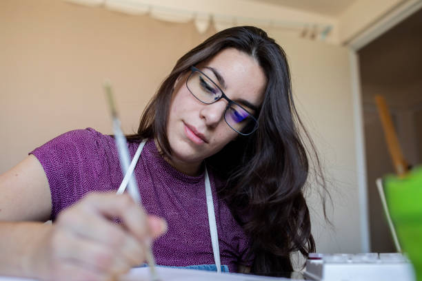 istock Young woman working on a painting 1372365880