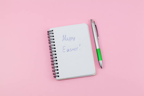 istock Notepad and pen on pink background. Notebook for ideas message, list and inspiration. Lettering Happy Easter 1372368264