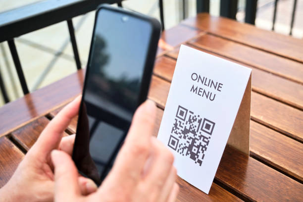 istock Hands of an unrecognizable woman scanning a QR code to access a restaurant menu 1372370811