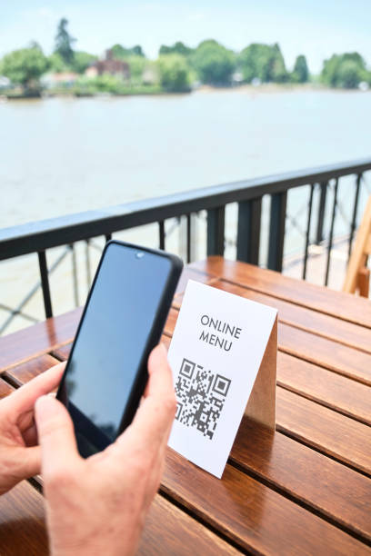 istock Hands of an unrecognizable woman scanning a QR code to access a restaurant menu 1372370860