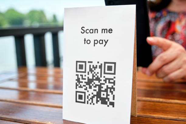 istock Unrecognizable female client scanning a QR code with her phone to pay cashless. 1372370943