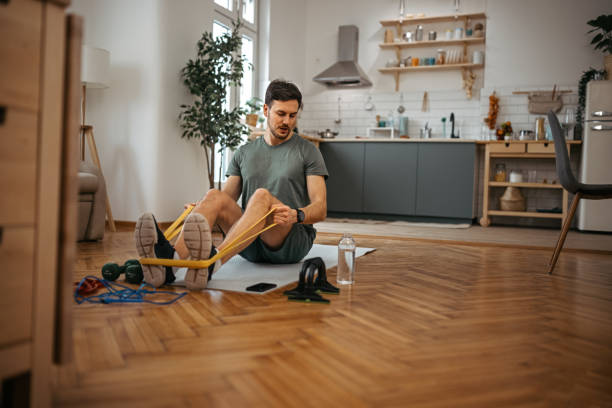 istock Man exercising with resistance band at home 1372372281