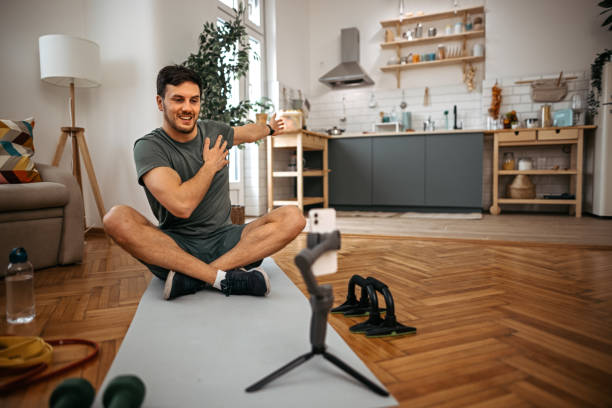 istock Man exercising  while recording live streaming on mobile phone at home 1372372632