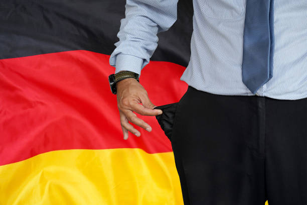 mann krempelt hosentasche auf dem hintergrund der deutschlandfahne auf - pants suit pocket men stock-fotos und bilder