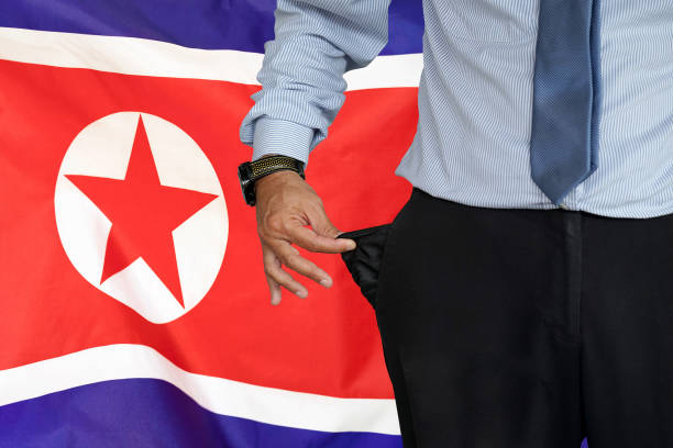 mann dreht seine hosentasche auf dem hintergrund der nordkoreanischen flagge hoch - pants suit pocket men stock-fotos und bilder