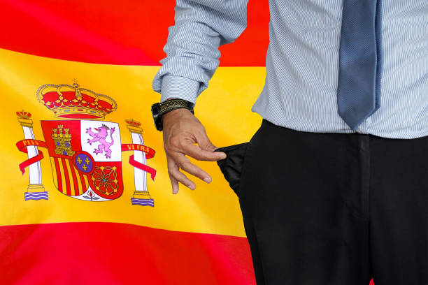 mann dreht seine hosentasche auf dem hintergrund der spanischen flagge hoch - pants suit pocket men stock-fotos und bilder