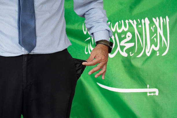 mann dreht seine hosentasche auf dem hintergrund der saudi-arabischen flagge hoch - pants suit pocket men stock-fotos und bilder