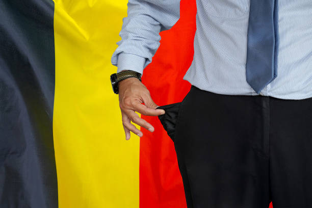 mann dreht seine hosentasche auf dem hintergrund der belgischen flagge hoch - pants suit pocket men stock-fotos und bilder