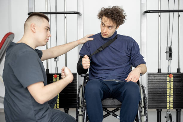 istock Rehabilitation specialist with guy on a wheelchair doing exercise 1372373926