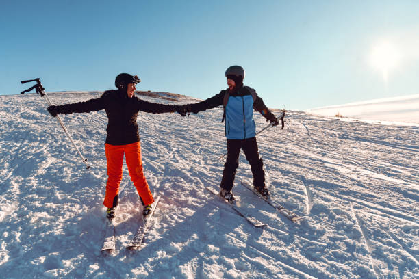 istock Skiing Couple Holding Hands While Sliding Downhill 1372374937