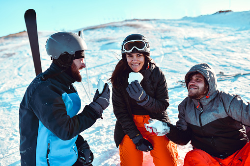 Smiling Friends Enjoying Winter Vacation And Eating Snow