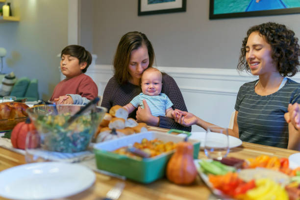 istock Family saying grace at holiday dinner table 1372375168
