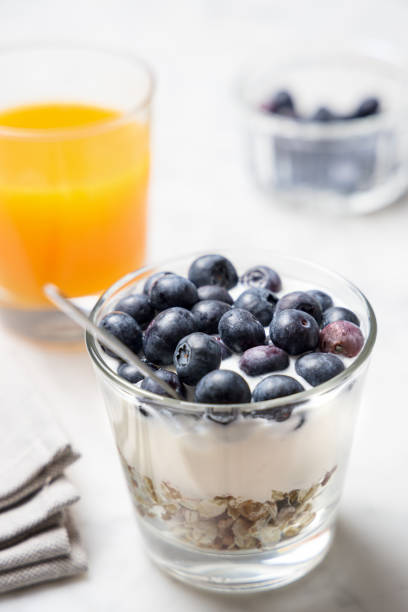 Healthy breakfast with muesli, yogurt and fruit, coffee cup and orange juice