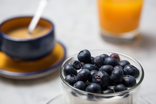 Healthy breakfast with muesli, yogurt and fruit, coffee cup and orange juice