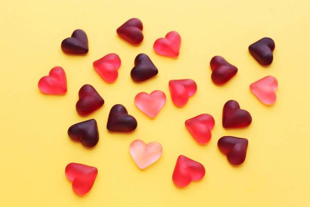 voluminous, translucent hearts in pink tones on a yellow background, bright color - valentine candy imagens e fotografias de stock