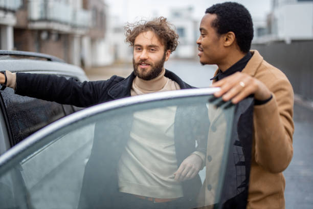 istock Two men flirting while standing near car on the street 1372376685