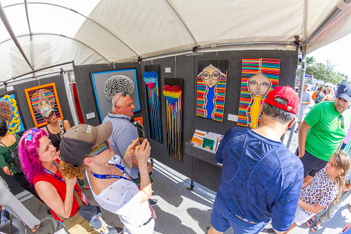 Miami, Florida, USA - February 21, 2022: Nationals and Internationals tourists and Collectors enjoying President's Day National Holidays at Coconut Art Festival; looking to buy some pieces of Arts in a sunny summer day at Regatta Park in Coconut Grove's neighborhood.