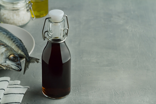prepared by fermentaion of fish salty sauce garum in a bottle on grey background