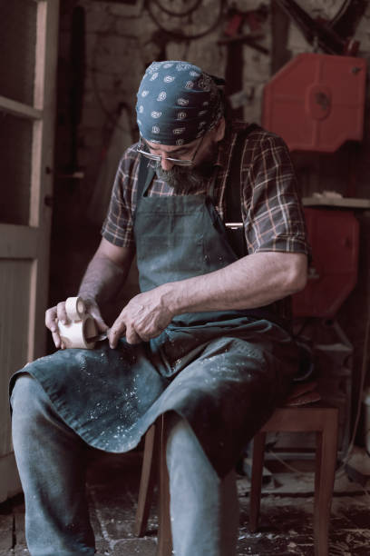istock Spoon craft master in his workshop with handmade wooden products and tools working 1372383124