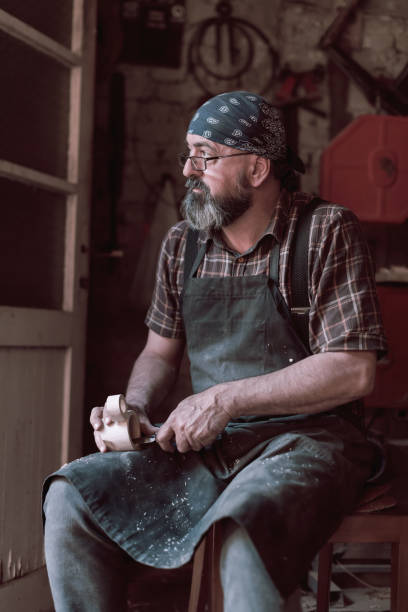 istock Spoon craft master in his workshop with handmade wooden products and tools working 1372383275