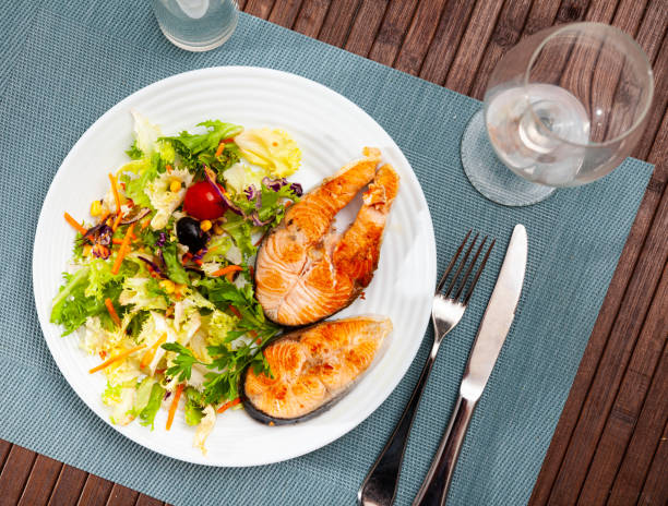 istock Salmon steak with parsley, corn, lettuce, carrot salad 1372384508