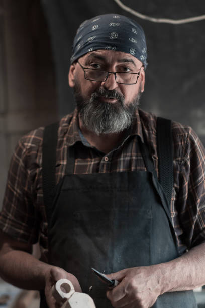 istock Spoon master in his workshop with wooden products and tools 1372386083