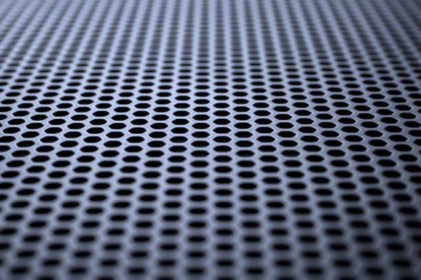 istock Metallic surface with regular round holes. Industrial background (abstract) 1372388264