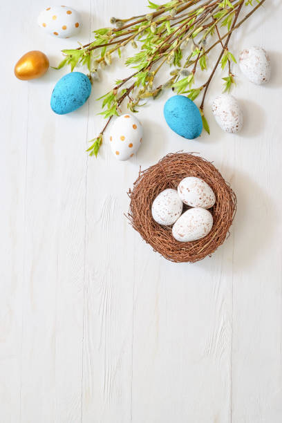 istock Branches with green leaves and easter eggs on a light background. Happy easter flat lay concept 1372389212