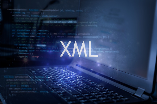 XML inscription against laptop and code background. Technology concept.