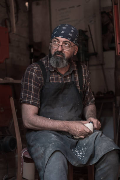 istock Spoon craft master in his workshop with handmade wooden products and tools working 1372392599