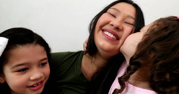 istock Asian mother holding and embracing daughters 1372397915
