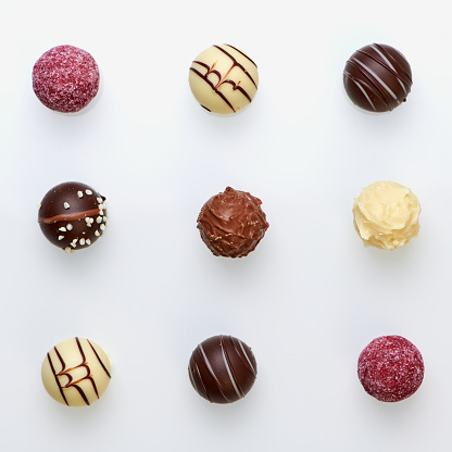 nine different chocolate truffles on white background
