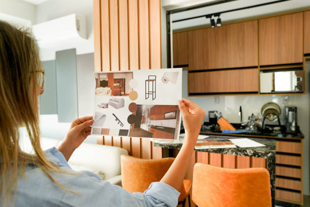 female architect looking at the picture of interior design - home decorating interior designer blueprint planning imagens e fotografias de stock