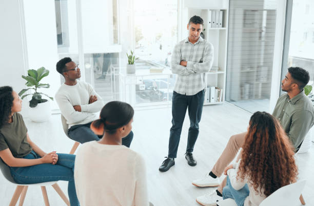 istock Shot of a handsome young man standing and talking to his support group 1372403177