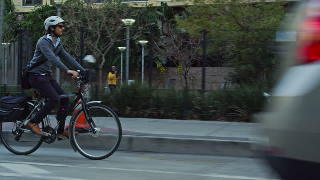 Commuter Riding Past Park in Protected Bike Lane