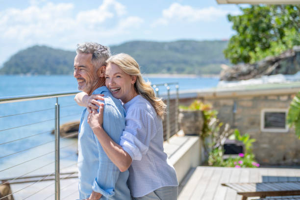 Mature couple embracing on vacation with the ocean in the background. stock photo