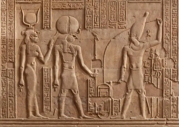 Ancient relief of Kom Ombo temple in Aswan Governorate, Upper Egypt. It was constructed during the Ptolemaic dynasty, 180-47 BC. Ra God, Hathor Goddess and Pharaoh